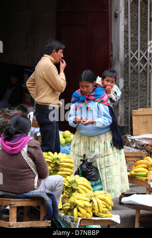 Amara Dame oder Cholita kauft Obst im Mercado Rodriguez, einem typischen Straßenmarkt in der Nähe des Stadtzentrums, La Paz, Bolivien Stockfoto