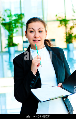 Junge Brünette Frau in Business-Anzug grübelte über das Angebot Stockfoto