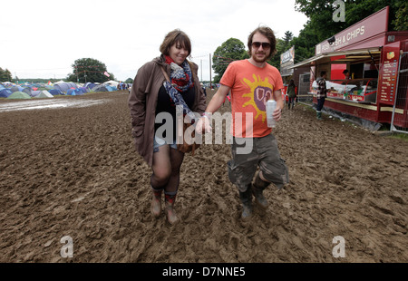 BESUCHERINNEN / BESUCHER ZU FUß DURCH SCHLAMM UND PFÜTZEN BEI NÄSSE BEI LATITUDE FESTIVAL, SOUTHWOLD, SUFFOLK, 2012 Stockfoto