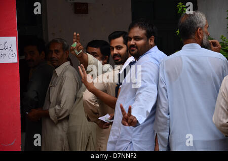 Rawalpindi, Pakistan. 11. Mai 2013.  Menschen Geste Victory-Zeichen, wie sie die Warteschlange um ihre Stimme abzugeben. Bildnachweis: Muhammed Furqan/Alamy Live-Nachrichten Stockfoto