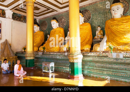 Nonne und Frau beten vor Buddhas in der Shwedagon Pagode in Yangon Myanmar 1 Stockfoto