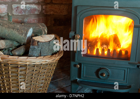 Holzbefeuerter Ofen mit einem Korb von Protokollen Stockfoto