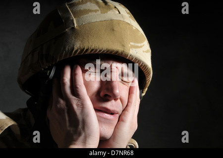 Britischer Soldat leiden Kriegszittern/PTSD, vor einem schwarzen Hintergrund. Stockfoto