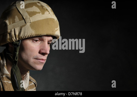 Nachdenklich Soldat vor einem dunklen Hintergrund. Soldat könnte von PTBS leiden. Stockfoto
