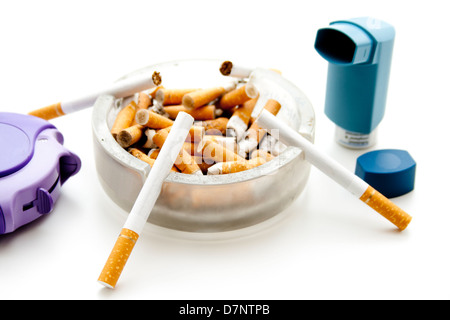 Volle Aschenbecher mit Asthma-spray Stockfoto