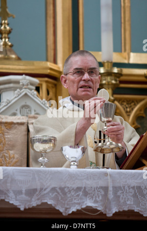 Ein katholischer Priester feiert die Messe mit der Heiligen Eucharistie und Kelch Stockfoto