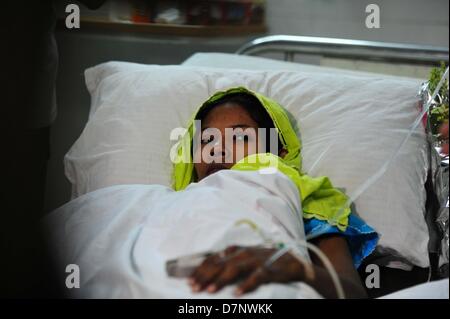 Savar, Bangladesch. 11. Mai 2013. Bangladeshi garment worker Reshma, der siebzehn Tage überlebt nach einem achtstöckigen Gebäude eingestürzt, ruht in Savar Cantonment Krankenhaus am Stadtrand von Dhaka am 11. Mai 2013. Die behandelnden Ärzte ein 'Wunder' Überlebenden zogen von den Ruinen einer eingestürzten Gebäude nach 17 Tagen sagte, dass sie Tat 'große' und hatte mit ihrer Familie wieder vereint. Reshma, 18, eine Näherin gegraben aus aus dem Schutt der Textilfabrik komplex", gab nie auf Hoffnung", aus den Trümmern gerettet werden würde. Stockfoto