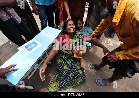 Savar, Bangladesch. 11. Mai 2013. Ein Bangladeshi Familienmitglied Schreie, als sie oben hält das Porträt ihres fehlenden relative, geglaubt, in den Trümmern einer 8-stöckigen Gebäude Einsturz in Savar gefangen zu sein, in der Nähe von Dhaka. Die behandelnden Ärzte ein 'Wunder' Überlebenden zogen von den Ruinen einer eingestürzten Gebäude nach 17 Tagen sagte, dass sie Tat 'große' und hatte mit ihrer Familie wieder vereint. Reshma, 18, eine Näherin gegraben aus aus dem Schutt der Textilfabrik komplex", gab nie auf Hoffnung", aus den Trümmern gerettet werden würde. Stockfoto