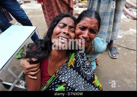 Savar, Bangladesch. 11. Mai 2013. Ein Bangladeshi Familienmitglied Schreie, als sie oben hält das Porträt ihres fehlenden relative, geglaubt, in den Trümmern einer 8-stöckigen Gebäude Einsturz in Savar gefangen zu sein, in der Nähe von Dhaka. Die behandelnden Ärzte ein 'Wunder' Überlebenden zogen von den Ruinen einer eingestürzten Gebäude nach 17 Tagen sagte, dass sie Tat 'große' und hatte mit ihrer Familie wieder vereint. Reshma, 18, eine Näherin gegraben aus aus dem Schutt der Textilfabrik komplex", gab nie auf Hoffnung", aus den Trümmern gerettet werden würde. Stockfoto