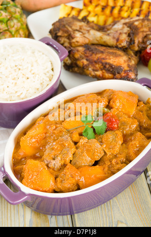 Lamm und Süßkartoffel-Erdnuss-Eintopf mit Reis serviert. Jerk Chicken. Karibik und westafrikanischen traditionelle Gerichte. Stockfoto