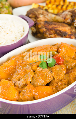 Lamm und Süßkartoffel-Erdnuss-Eintopf mit Reis serviert. Jerk Chicken. Karibik und westafrikanischen traditionelle Gerichte. Stockfoto