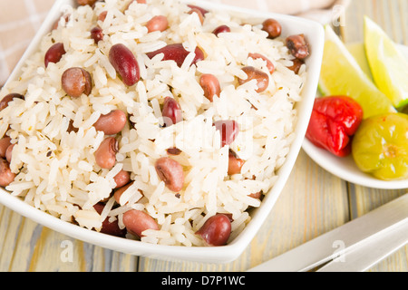 Reis und Erbsen - karibische Kokos Reis mit roten Bohnen, Kuhbohnen und Straucherbsen. Scotch Bonnet Chili und Limette auf Seite. Stockfoto