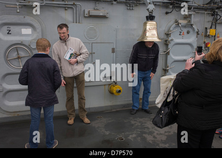 Besucher bewundern die Schiffsglocke während einer Tour durch dem oberen Deck an Bord Flugzeugträger der Royal Navy HMS Illustrious während eines öffentlichen Open-Tages in Greenwich. Illustrious angedockt an der Themse, so dass die Steuern zahlenden öffentlichen um den Decks vor seiner bevorstehenden Decommisioning zu erkunden. Navy Personal half mit dem PR-Event über die Mai Wochenende, historisch der Heimat England Flotte. Stockfoto