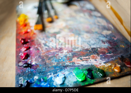 Öl gemischt Farben auf Holzpalette mit Bürsten Stockfoto