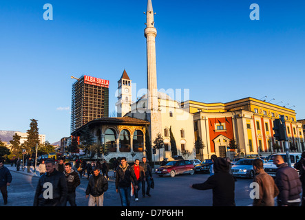 Menschen überqueren Skanderbeg-Platz mit Ethem Bey-Moschee im Hintergrund. Tirana, Albanien Stockfoto