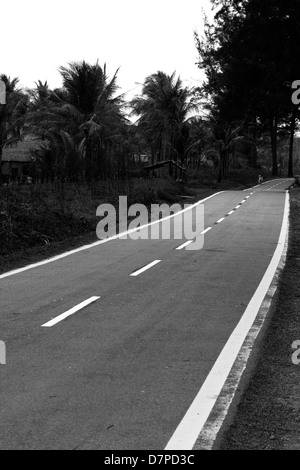 SABAH STATE, Ost-MALAYSIA 30. September 2009: Eine schmale zweispurige Landstraße schlängelt sich durch Wald in der Nähe von Kudat, der Tipp von Borneo. Stockfoto