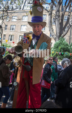 London, UK. 12. Mai 2013. Ein Clown auf Stelzen posiert mit seinem Fahrrad. Paul Davey/Alamy Live-Nachrichten Stockfoto