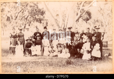 Ein Outdoor-Gruppenporträt aus dem Jahr 1884, das Frauen und Kinder mit Regenschirmen zeigt. Das Foto fängt einen Moment in der Zeit ein und spiegelt die Mode und soziale Dynamik der Zeit wider. Dieses Bild ist Teil der Sammlung des Powerhouse Museums. Stockfoto