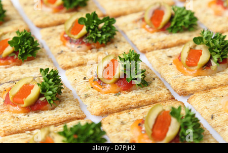 Snacker Cracker - Weizen Cracker belegt mit Käse, Oliven, Petersilie und Sauce gebacken. Stockfoto