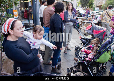 Jerusalem, Israel. 12. Mai 2013. Baby Kinderwagen Demonstranten rufen gegen kürzlich ernannten Finanzminister Lapid, war die Hoffnung der Mittelklasse- aber jetzt verlorene Popularität, während anspruchsvolle subventionierte am Nachmittag Kinderbetreuung. Jerusalem, Israel. 12. Mai 2013.  Mehrere Dutzend Kinderwagen Demonstranten marschieren mit Kindern Jerusalems Emek Refaim Straße demonstrieren gegen Regierung Budgetkürzungen und anspruchsvolle subventionierte am Nachmittag Kinderbetreuung. Bildnachweis: Nir Alon/Alamy Live-Nachrichten Stockfoto