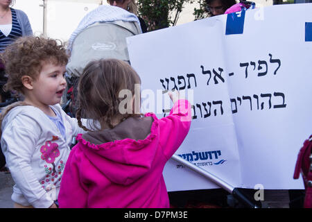 Jerusalem, Israel. 12. Mai 2013. Baby Kinderwagen Demonstranten rufen gegen kürzlich ernannten Finanzminister Lapid, war die Hoffnung der Mittelklasse- aber jetzt verlorene Popularität, während anspruchsvolle subventionierte am Nachmittag Kinderbetreuung. Jerusalem, Israel. 12. Mai 2013.  Mehrere Dutzend Kinderwagen Demonstranten marschieren mit Kindern Jerusalems Emek Refaim Straße demonstrieren gegen Regierung Budgetkürzungen und anspruchsvolle subventionierte am Nachmittag Kinderbetreuung. Bildnachweis: Nir Alon/Alamy Live-Nachrichten Stockfoto