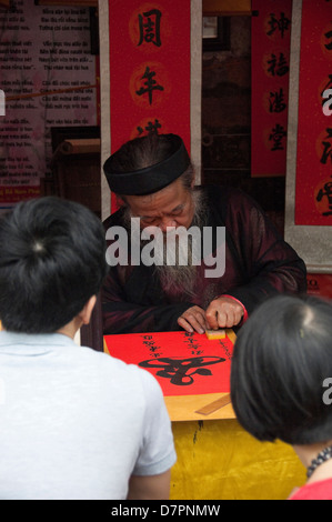 Vertikale Bildniss eines Calligraphist außerhalb der Temple of Literature in Hanoi an einem sonnigen Tag. Stockfoto