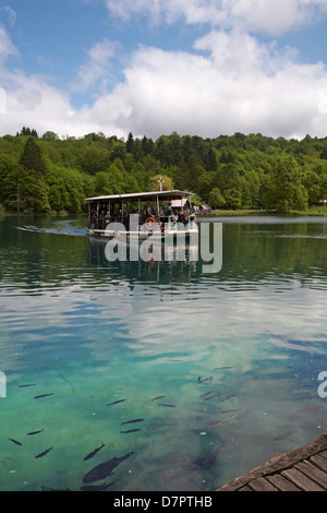 Touristenboot überquert den Kozjak-See im Nationalpark Plitvicer Seen, ein UNESCO-Weltkulturerbe, in Kroatien im Mai - Plitvicer Nationalpark Stockfoto