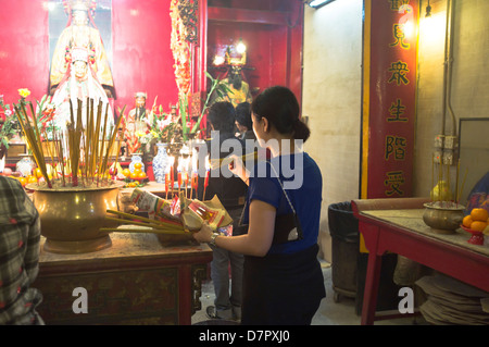 dh man Mo Tempel SHEUNG WAN HONGKONG man Mo Tempel Mädchen Beleuchtung joss Stick chinesischen Tempel Schrein bietet Religion Frau Weihrauch china taoistische Szene Stockfoto