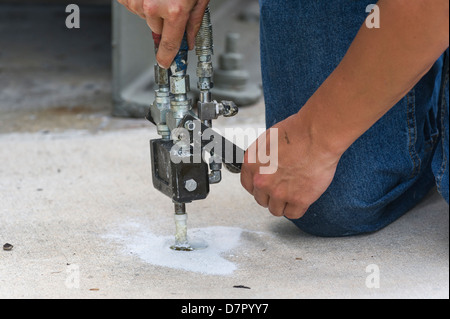 Chemische Mörtel füllen die Hohlräume unter einigen Betonplatten auf die Burrell Verriegelung und Verdammung in Leesburg, Florida installiert wird Stockfoto