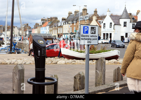 Frau betrachten ein Pod Punkt Parkplatz Ladegerät für ein Elektroauto in der Fife coastal Stadt von Anstruther Stockfoto