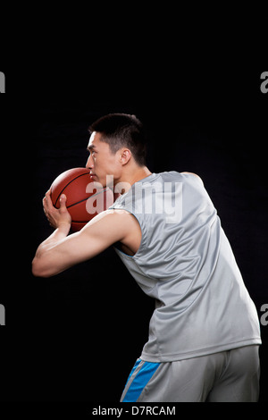 Basketball-Spieler bereit, Kugel, schwarzen Hintergrund zu werfen Stockfoto