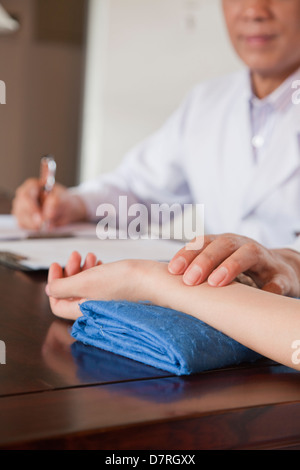 Nahaufnahme der Hand des Patienten, während Doktor Puls nimmt Stockfoto