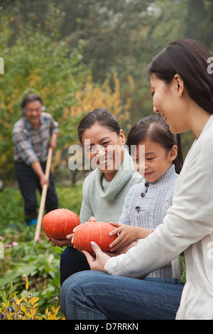 Glückliche Familie Ernte Gemüse im Garten Stockfoto