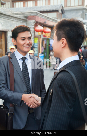 Zwei junge Unternehmer Handshaking in Houhai, Peking, China Stockfoto