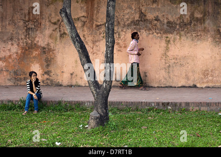 Eine Mädchen beobachtet einen Mann, wie er durch die Gärten des Lalbagh Fort in Dhaka, Bangladesch geht Stockfoto