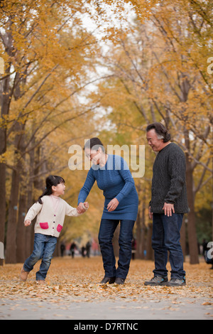 Großeltern und Enkelin spielen im park Stockfoto