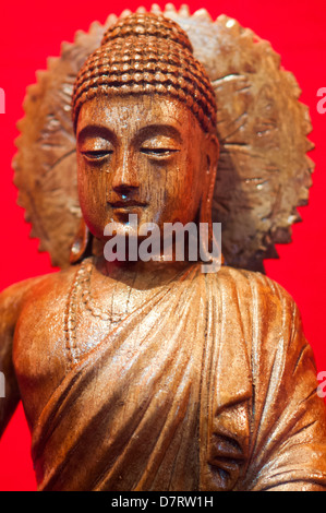 Hölzernen Buddhastatue in rotem Hintergrund Stockfoto