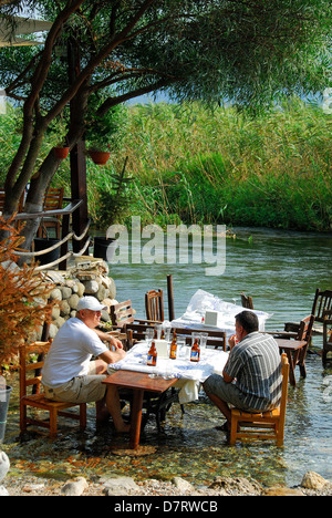 AKYAKA, ÄGÄIS, TÜRKEI. Zwei Männer trinken Bier und kühlen ihre Füße im Fluss Azmak. 2011. Stockfoto