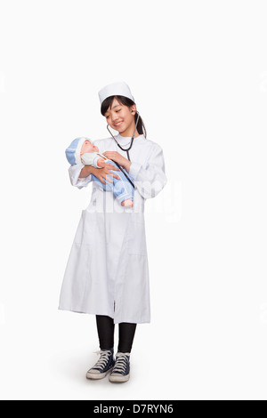 Mädchen verkleidete sich als Arzt der Puppe Vitalfunktionen überprüfen Stockfoto