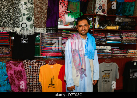 Lokaler Arabische Mann fotografiert neben der Kleidung Regal in seinem Geschäft in der alten Souk Dubai Stockfoto