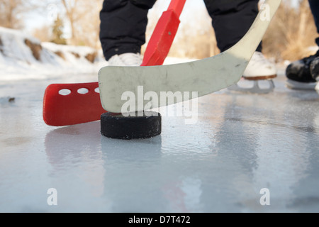 Kinder spielen Eishockey auf dem zugefrorenen Bach Stockfoto