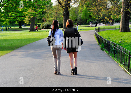 Zwei junge Frauen gehen im Regents Park, London, UK Stockfoto