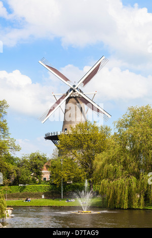 Leiden, Holland, im Frühjahr - traditionelle Mühle Museum De Valk auf dem Fluss Oude mit Brunnen und Bäume Stockfoto