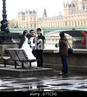 Frisch verheiratet japanisches Ehepaar mit ihrem Fotografen nach posiert vor The Houses of Parliament. Mai 2013 Stockfoto