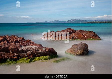 Lange Exposition Bild des Meerwassers auf der Durchreise Felsen am Strand von Palombaggia, im Süden von Korsika. Stockfoto