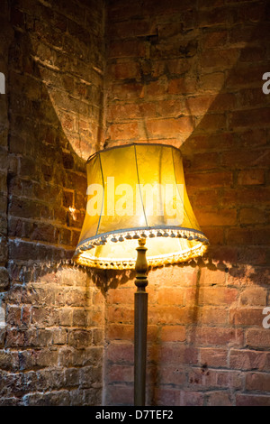 Ein Foto von einer Stehlampe in der Ecke der zwei Ziegelwände. Es wirft einen interessanteren strukturierte Schatten. Stockfoto