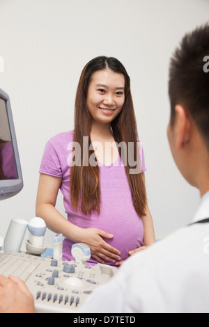 Schwangere Frau im Gespräch mit Arzt Stockfoto