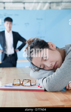 Junge Geschäftsfrau schlafen während der Sitzung, enttäuscht Chef sah Sie Stockfoto