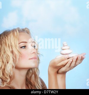 Closeup Portrait der hübsche blonde Mädchen holding Spa Steinen im Freien, Zen, Entspannung Open-Air, Luxus-Spa-Salon, Beauty-Behandlung Stockfoto