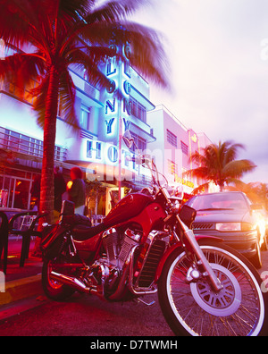 Harley Davidson Motorrad vor den Art-Deco-Hotels nachts am Ocean Drive, Miami, Florida, USA Stockfoto